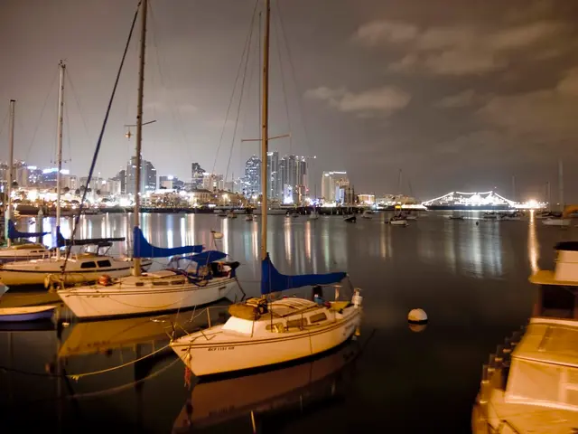 On the left side there are boats in this water, at the back side there are big buildings with the...